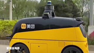 Chiếc xe tự lái chở đồ ăn đi đang chạy bình thường, và anh chàng chở đồ ăn đi phía sau đã đuổi theo 