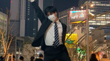 Seorang pria berjas menari Tomboy di jalanan Shibuya