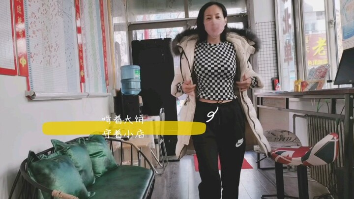 أم وحيدة تقضم فطيرة كبيرة، وتراقب متجرها الصغير، محاولةً بجدّية اجتياز الشهر الأخير من عام 2021