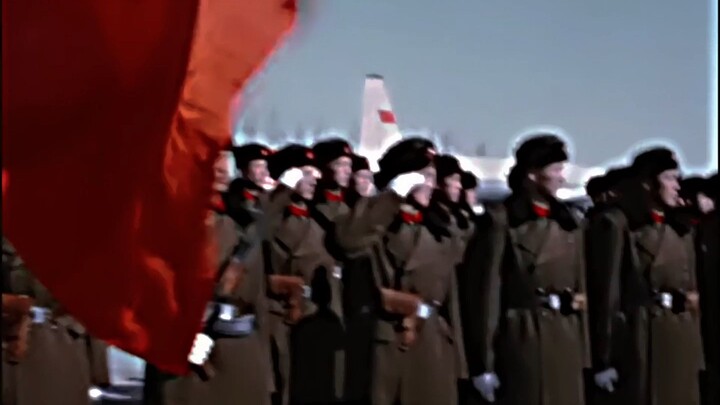 Bintang merah dikenakan di kepala, dan bendera merah revolusioner digantung di kedua sisi