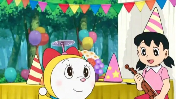 Doraemon, si pria gemuk biru, duduk di meja makan dengan penuh harap. Ibu Xiong membawakan sepiring 