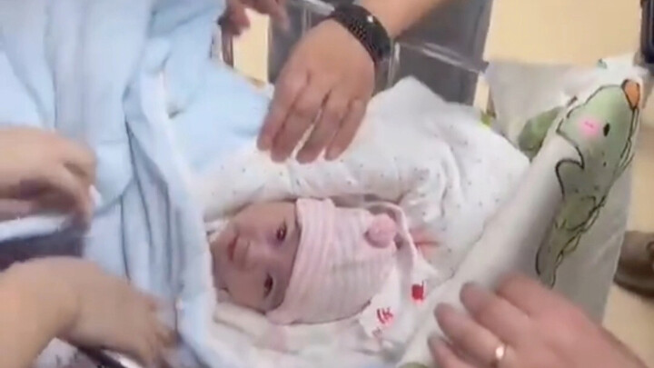 Chú bé vừa mới chạm đất đã được cô y tá khen nức nở — đôi mắt như thể hiểu hết mọi lời mọi người nói