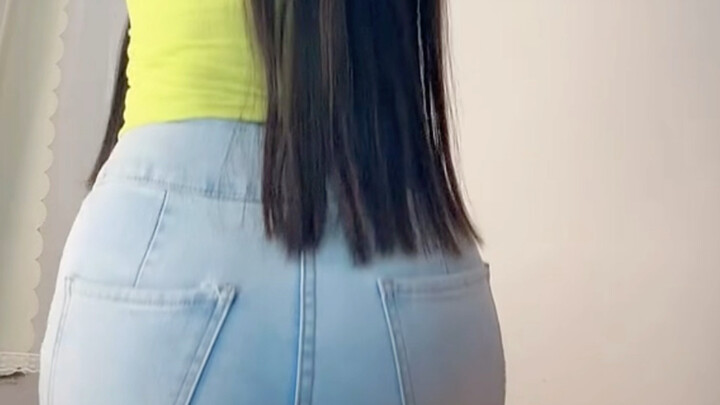 Bạn nhỏ đáng yêu tập squat với quần jean ở phía sau