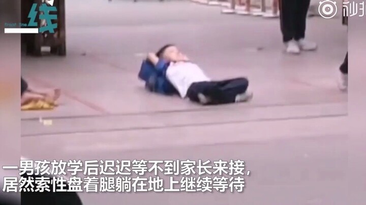 Elementary school students lie down at the school gate after class, waiting for their parents.