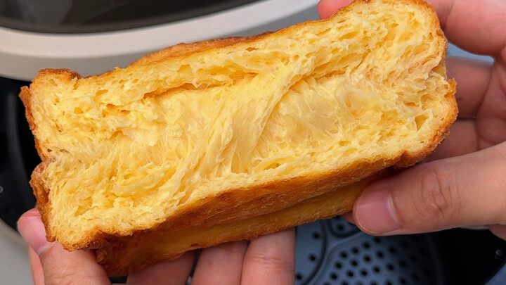 Lấy trứng và sữa đánh bông rồi nhúng bánh mì gối, cho vào nồi chiên không dầu nướng một chút, bên ng