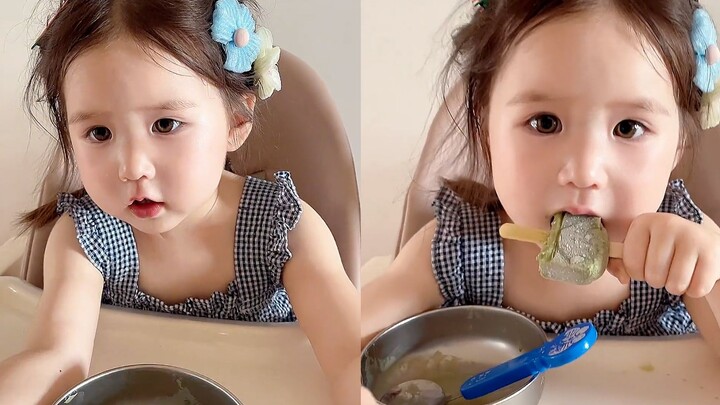 Ibu dan anak perempuan berbagi es loli dengan garis pembatas; si angsa kecil manis menunggu dengan p