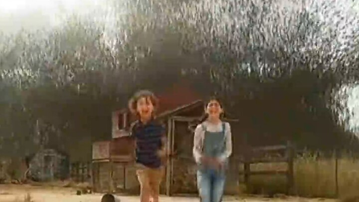 A little girl is feeding the chickens on a farm when she suddenly spots a grasshopper about the size