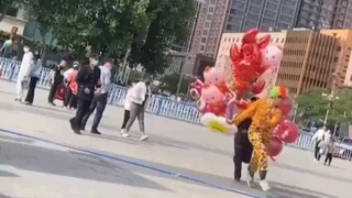 Một chú hề bán bóng bay trước quảng trường bị đuổi đi một cách thô bạo, người bán hàng bất lực hét l