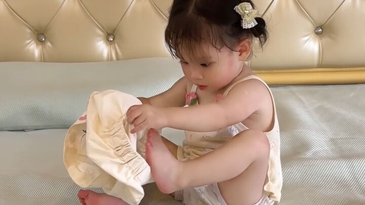 Bayi manusia berusia 1 tahun mencoba memakai celana sendiri, hampir membuat sang ayah tertawa terpin