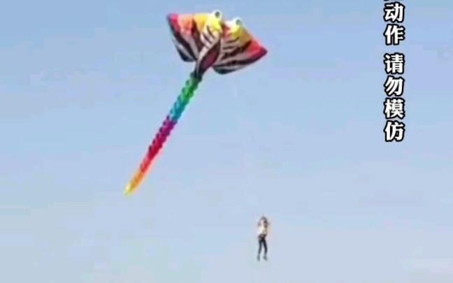 / Một người đàn ông thả diều khổng lồ nhưng không kịp buông tay, bất ngờ bị kéo lên高空; may mắn là kh