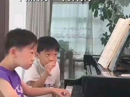 Little boy conducts his buddy as they play the piano—both teach and play like pros! This is what tru