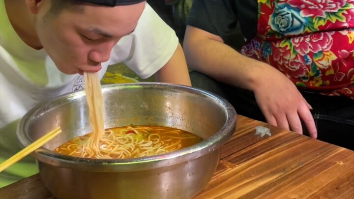This handsome guy insists on finishing five liang of snail noodles even in the rain. With him puttin