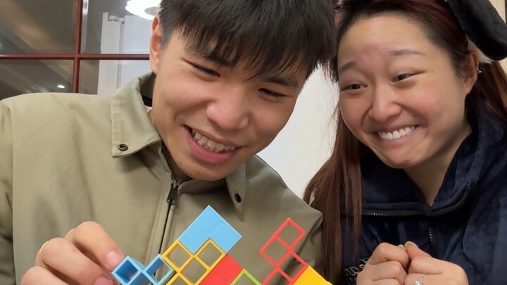 Watch couple playing with small building blocks