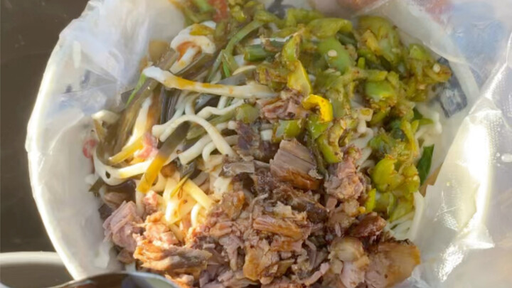 Meat-topped noodles for 13 yuan a bowl—big slices of green pepper and pork piled on top, fragrant bu