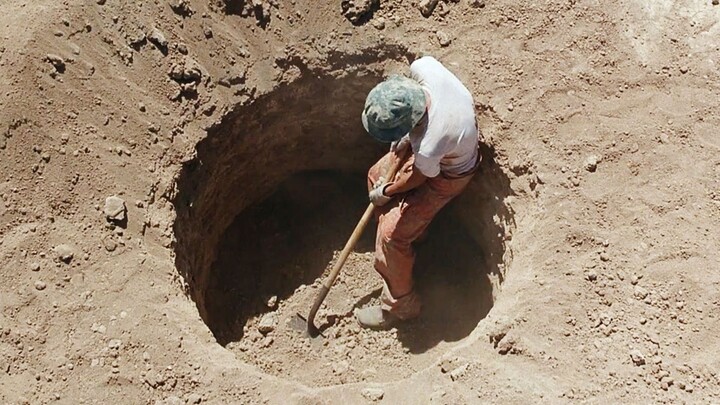 A mysterious prison where the warden has all inmates digging deep pits in the desert—because there’s