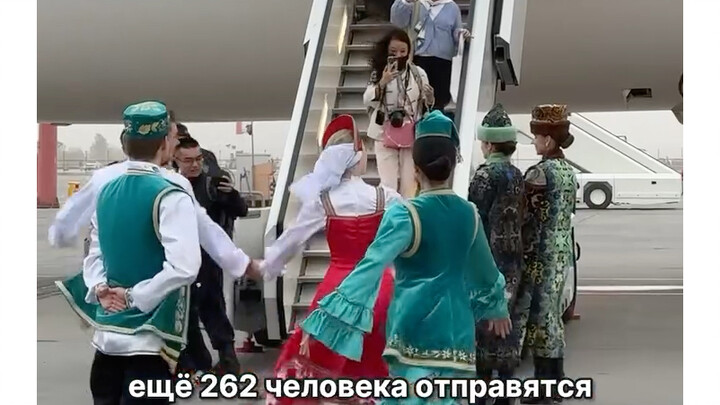 Behind me, the first group of passengers from Shanghai is walking down the jet bridge.