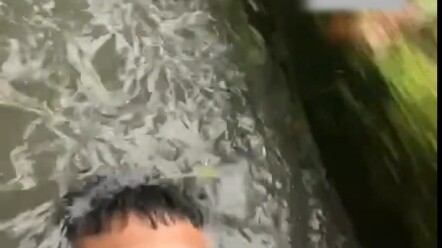 Man can’t catch the bus in the rain, so he just lies down in the drainage area.