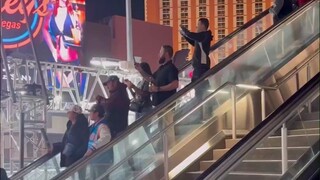 F1拉斯维加斯站比赛场地外，有一群没买票却想看比赛的人，他们反反复复上下自动扶梯