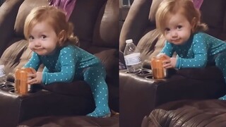 The cute kid got caught by mom sneaking a sip of sparkling water, her expression vivid and adorable—