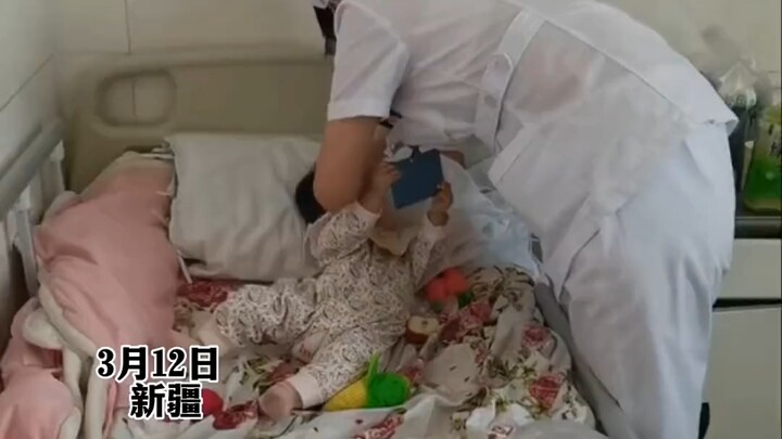 The nurse carefully examines the baby’s head, while the baby “checks the nurse’s ID”—each one mindin