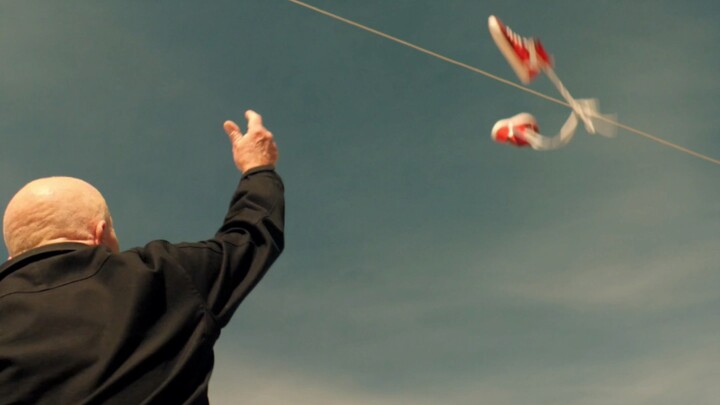 An elderly man sets a trap with shoes.