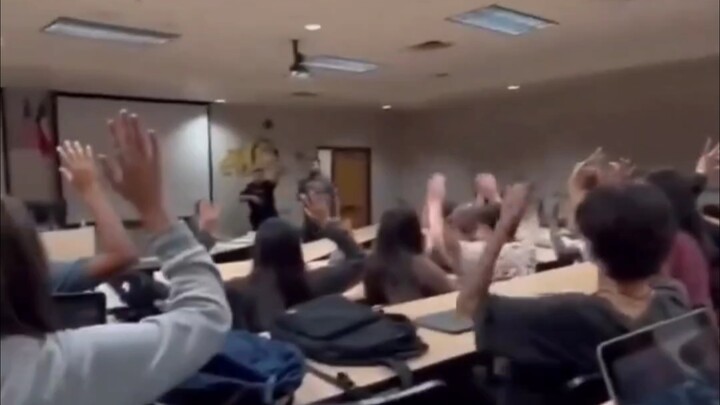 American college students actively raise their hands to answer questions in class.