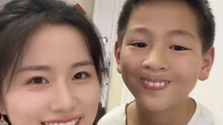 The girl put on makeup and wanted to take a photo with her brother. The brother smiled after being s