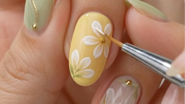 Pastel yellow and sage green floral nail art idea for almond nails! 🌼✨