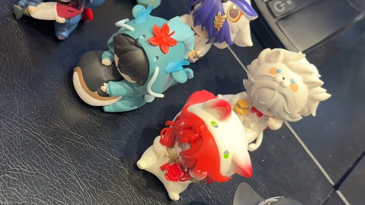 A group of people buys individual blind boxes and opens them...