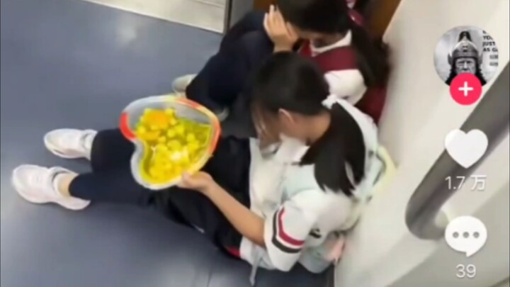 A Chinese little girl eats jelly on the subway, while the conductor pretends to enjoy the view—forei