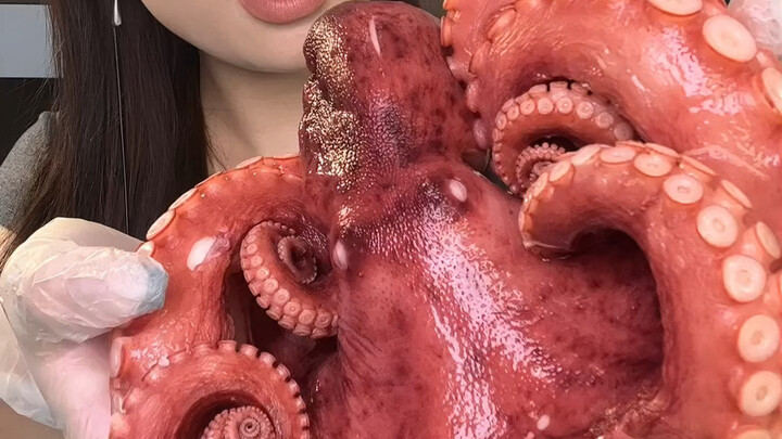 Wanita asyik makan seekor gurita utuh—renyah, empuk, dan berair!