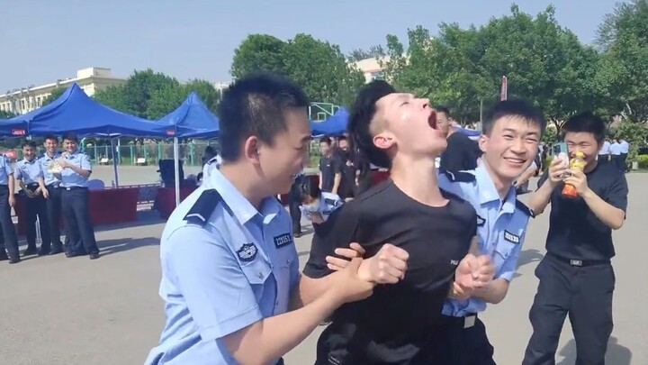 Seorang mahasiswa polisi mencoba belenggu elektronik dan berjalan kembali sambil tertawa, tapi kemud