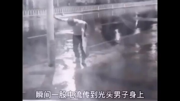 感人的一幕 下雨天该男子手碰灯杆触电，还好路边男子见状立即飞出一腿救人