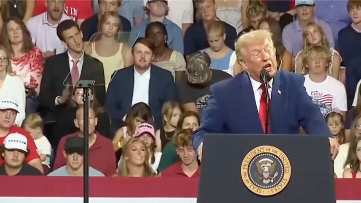 Man in suit behind Trump goes viral for mocking his mannerisms during a live rally