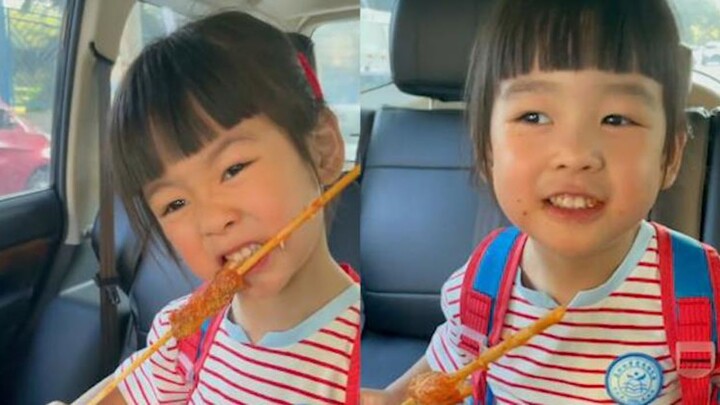 Dad picks up his daughter from school and buys grilled skewers for her. As she munches away, she sta