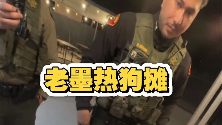 Gerobak hot dog Pak Mo, para petugas patroli mampir untuk makan malam; Pak Mo menyajikan hot dog lez