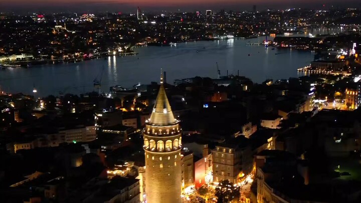 Mesmerizing night view of the illuminated Galata Tower under the crescent moon