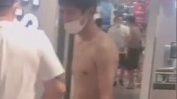 Một người đàn ông cởi trần có hình xăm bị chặn mua Red Star Erke, người bán hàng chào anh ta bằng mộ