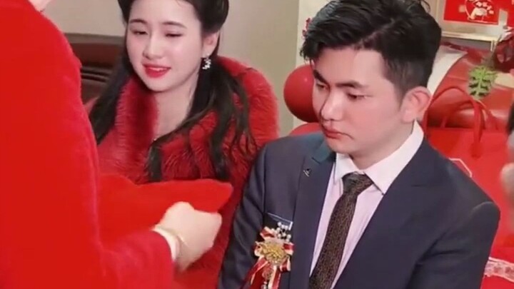 At a newlywed couple’s wedding, the bride in a stunning red gown is breathtakingly beautiful; netize