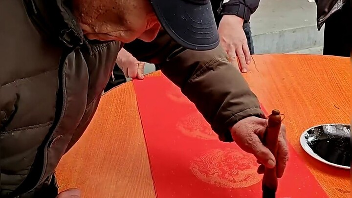 Amazing! The elderly man holds the brush in his left hand and writes so smoothly and powerfully.