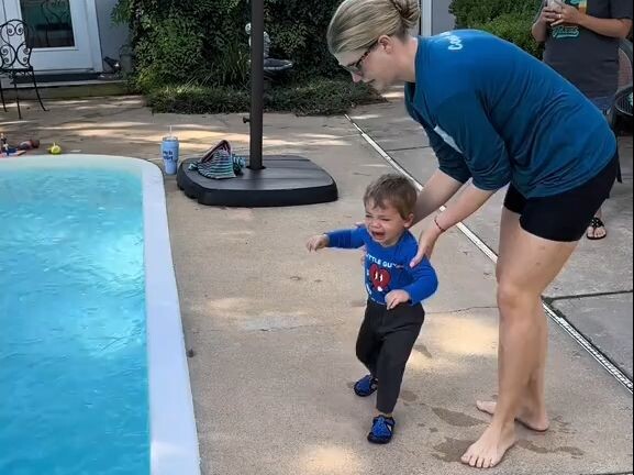 A foreign swimming coach picked up a crying baby and threw him directly into the swimming pool. The 
