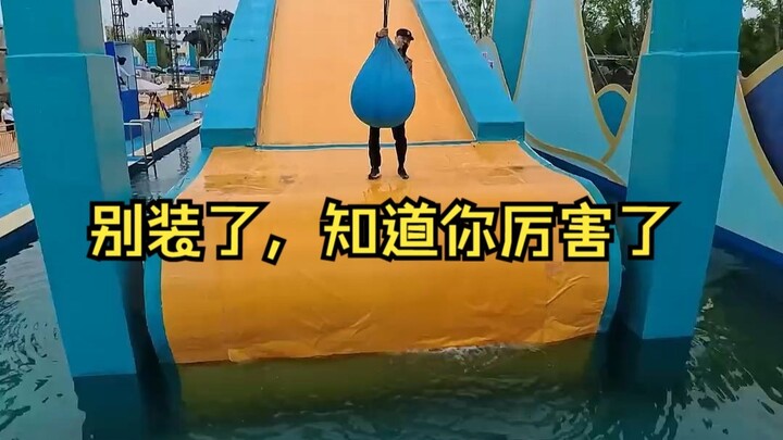 The young guy tackles the water obstacle course, looking back with every step—truly impressive!