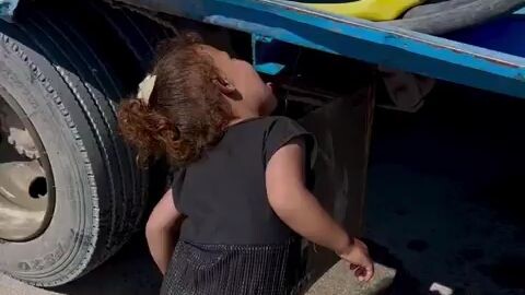 #Watch| A girl from Gaza tries to quench her thirst from water droplets falling from a truck.