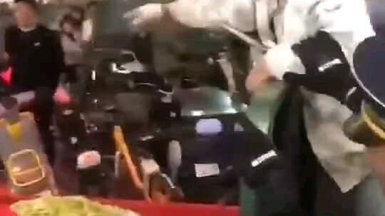 Urban management officers impound a vendor’s vehicle; the vendor pulls out a knife.