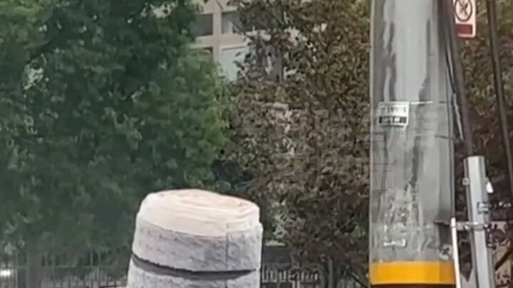 A huge bundle of goods fell right in the middle of the road, leaving a man flustered and at a loss. 