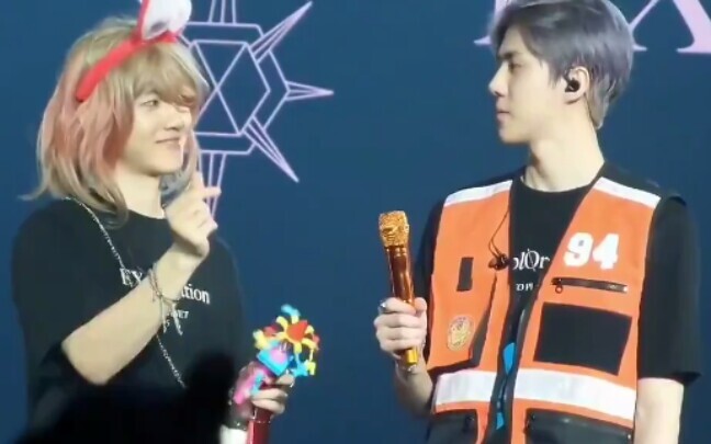 Two super-kid-like friends: Baekhyun makes a heart with his hands and tells Sehun to do the same, bu