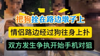 Pemilik anjing mengikat anjingnya pada batu tepi jalan, sementara pemiliknya duduk di samping. Sebua