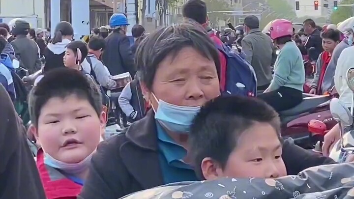 Đứa trẻ đứng trước cổng trường tìm mẹ đến đón. Mẹ: Con đang tìm gì thế? Có phải đang “chọn” mẹ à? Cư