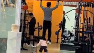 爸爸带着女儿在健身房做引体向上，女儿乖乖抱着爸爸双腿。网友：这是来炫女儿的吧。