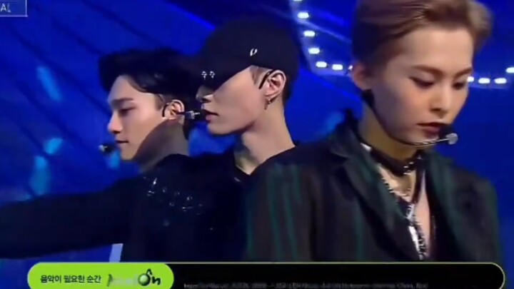EXO’s “Lotto”: Lay Zhang hopped off the plane, threw on a baseball cap, and headed straight onstage—
